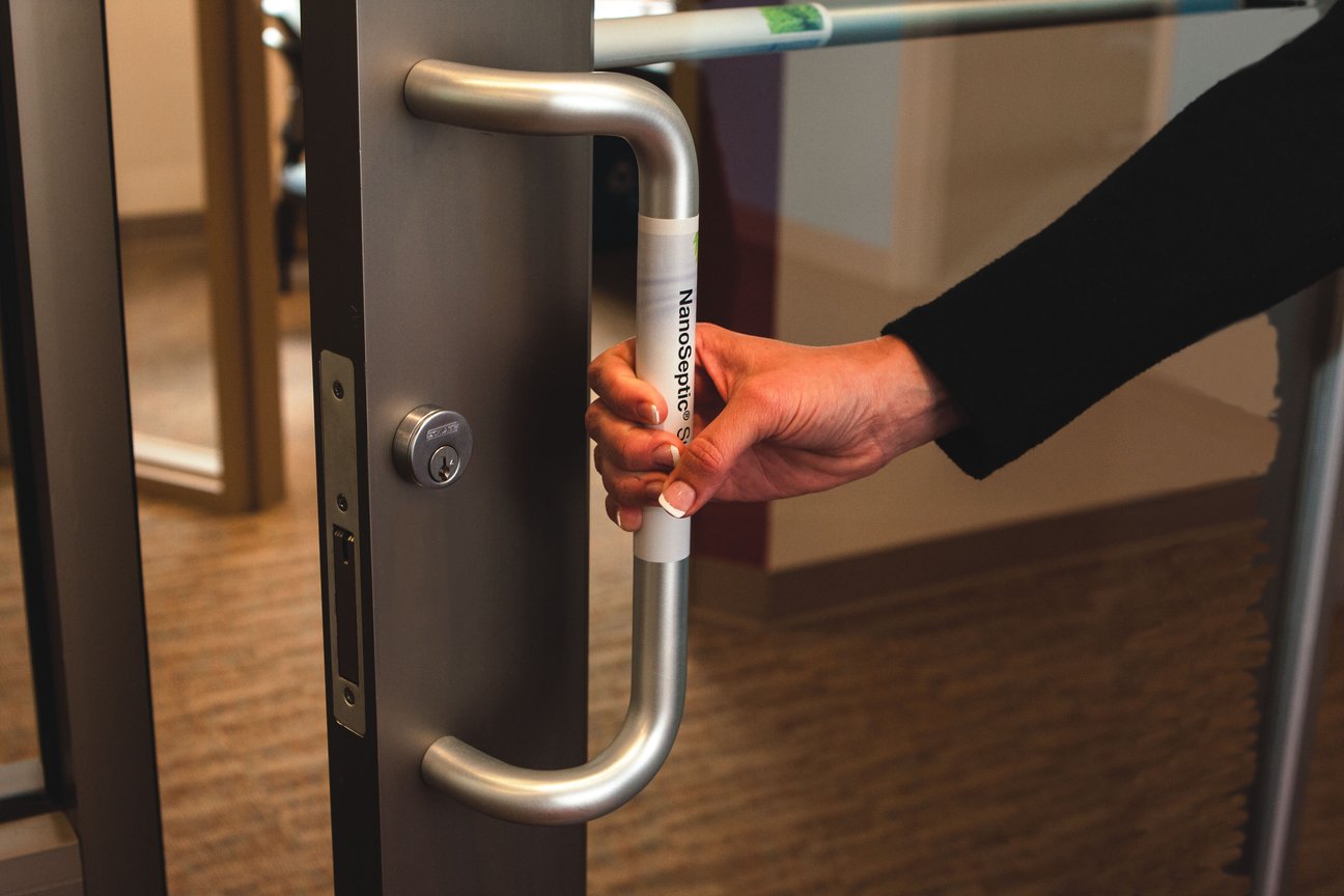 Woman opening door equipped with NanoSeptic strip