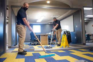 Professional carpet cleaning in an office wearing masks