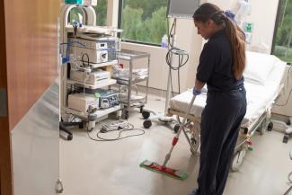 Employee mopping medical room floor