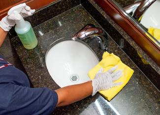 Janitronics cleaning technician wiping a sink