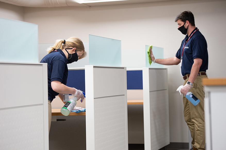 Janitronics frontline specialists wiping surfaces in an office